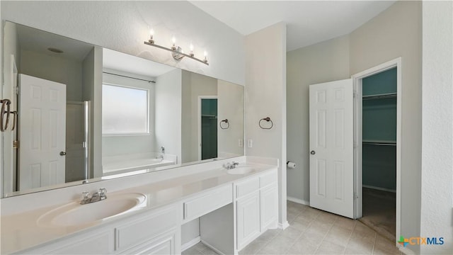 2166 Jolie Ct, New Braunfels, TX 78130 - full bathroom featuring a bath, double vanity, tile patterned flooring, and a walk in closet