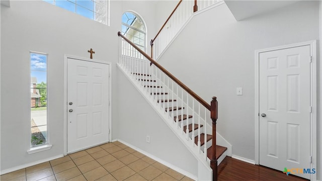 2166 Jolie Ct, New Braunfels, TX 78130 - foyer entrance with healthy amount of natural light, a towering ceiling, stairs, and tile patterned floors