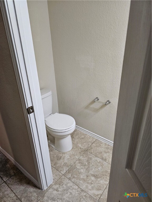 bathroom with tile patterned flooring and toilet