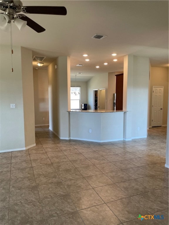 tiled spare room with ceiling fan