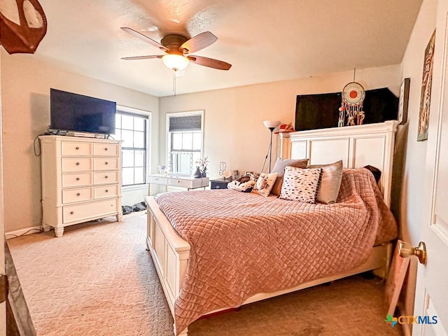 bedroom featuring light colored carpet and ceiling fan