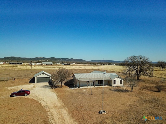 view of front of house with a rural view and a mountain view