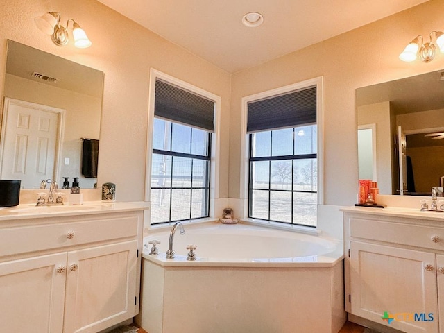 bathroom featuring vanity and a bath