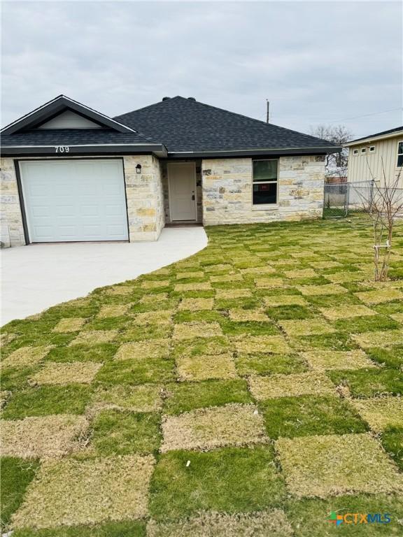 view of front of home featuring a garage and a front lawn