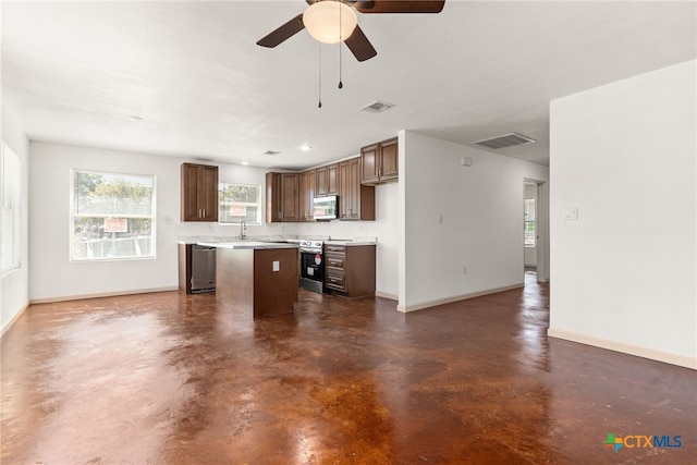 kitchen with ceiling fan, a kitchen island, sink, and stainless steel appliances