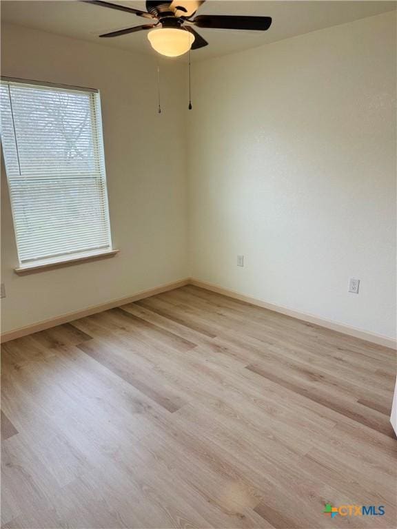 empty room with ceiling fan and light hardwood / wood-style floors