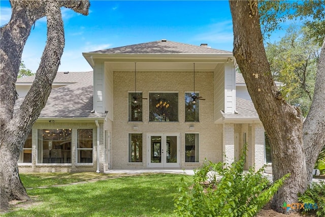 313 Treasure Oaks Rd, Inez, TX 77968 - rear view of property with french doors, brick siding, a shingled roof, and a yard