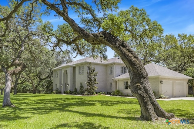 313 Treasure Oaks Rd, Inez, TX 77968 - view of front facade featuring an attached garage, a front lawn, driveway, and brick siding