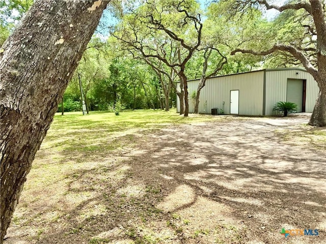 313 Treasure Oaks Rd, Inez, TX 77968 - view of grassy yard featuring an outbuilding, a garage, and a pole building