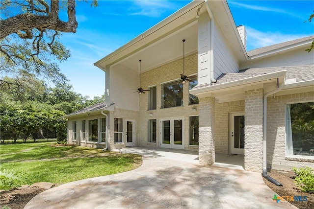 313 Treasure Oaks Rd, Inez, TX 77968 - back of property with french doors, ceiling fan, a patio area, a lawn, and brick siding