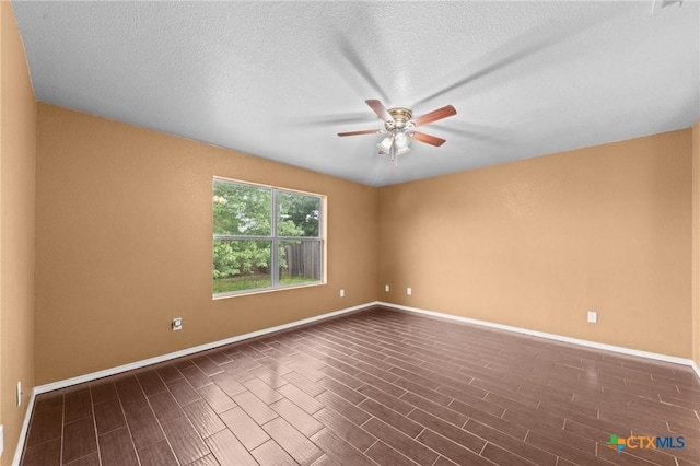 unfurnished room with baseboards, dark wood-type flooring, and ceiling fan