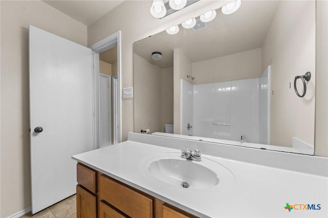 bathroom featuring vanity, tile patterned floors, toilet, and shower / washtub combination