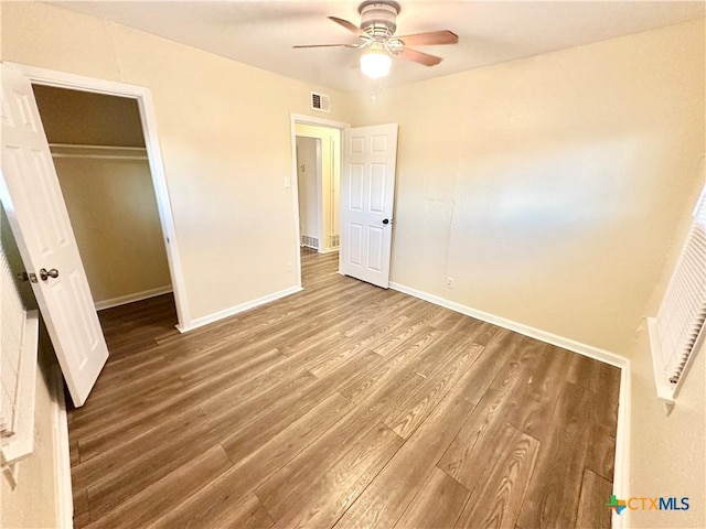 unfurnished bedroom featuring hardwood / wood-style floors, ceiling fan, and a closet