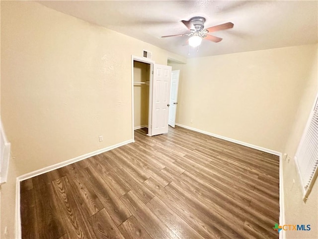 unfurnished bedroom with wood-type flooring, ceiling fan, and a closet