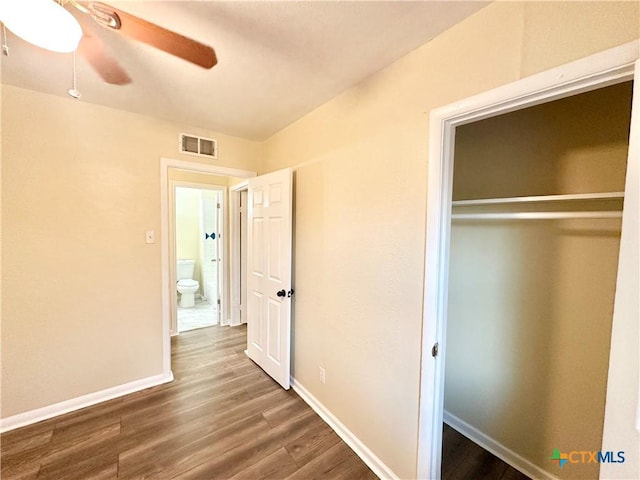 unfurnished bedroom with dark hardwood / wood-style floors, ceiling fan, and a closet