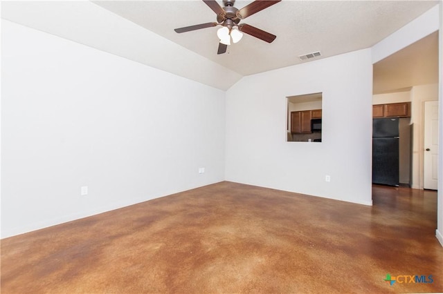 empty room featuring visible vents, vaulted ceiling, and a ceiling fan