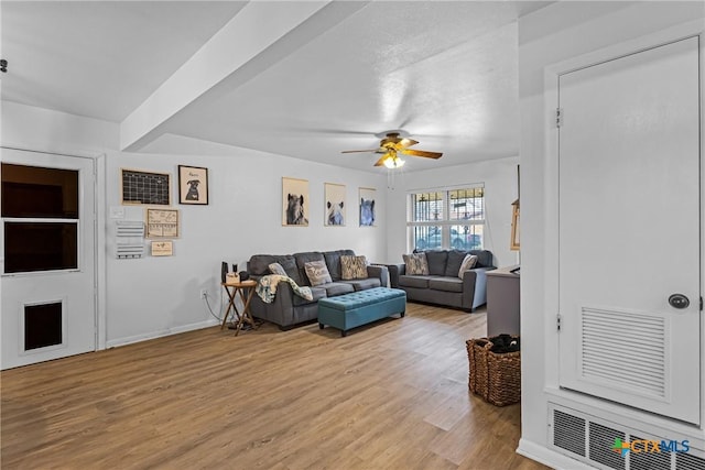 living area featuring a ceiling fan, light wood-style flooring, and baseboards