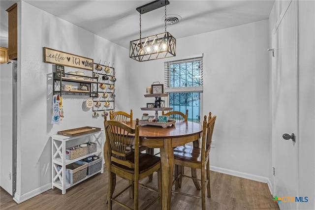 dining space featuring baseboards, visible vents, and wood finished floors