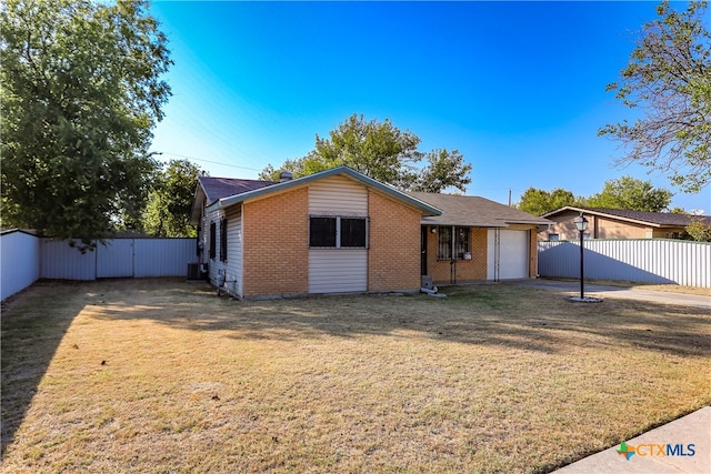 view of front of property featuring brick siding, central AC, fence, a garage, and a front lawn