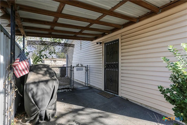 view of patio featuring a carport, grilling area, fence, and a gate