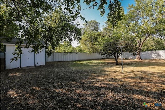 view of yard with a storage shed, an outdoor structure, and a fenced backyard