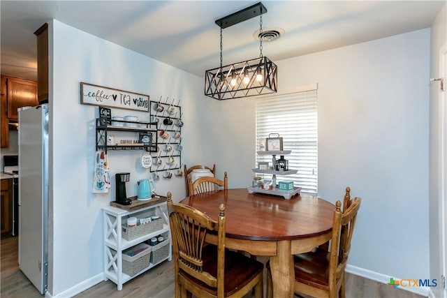 dining room featuring wood-type flooring and a chandelier