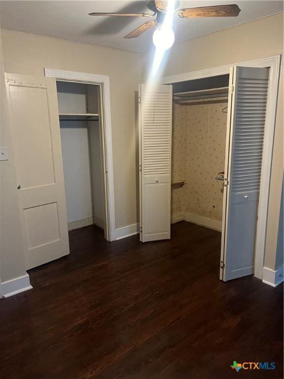 unfurnished bedroom with ceiling fan and dark hardwood / wood-style flooring