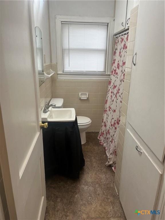 full bathroom with toilet, tile walls, vanity, and shower / tub combo