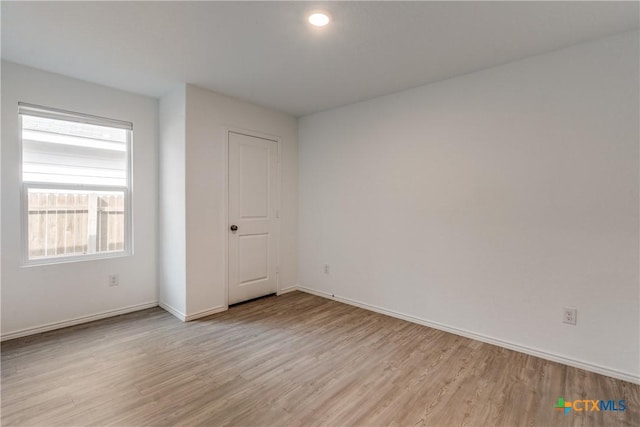 unfurnished bedroom with light wood-style flooring and baseboards