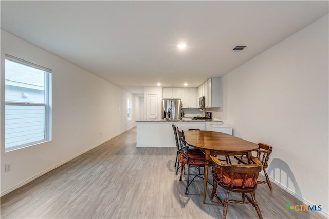 dining area featuring light wood finished floors, visible vents, a wealth of natural light, and recessed lighting