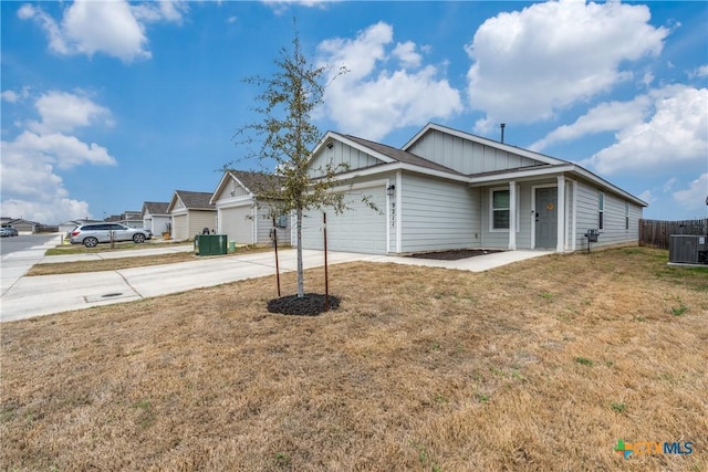 ranch-style house featuring an attached garage, board and batten siding, a front yard, fence, and driveway