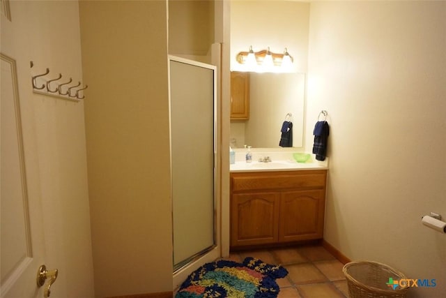 bathroom with tile patterned flooring, vanity, and walk in shower