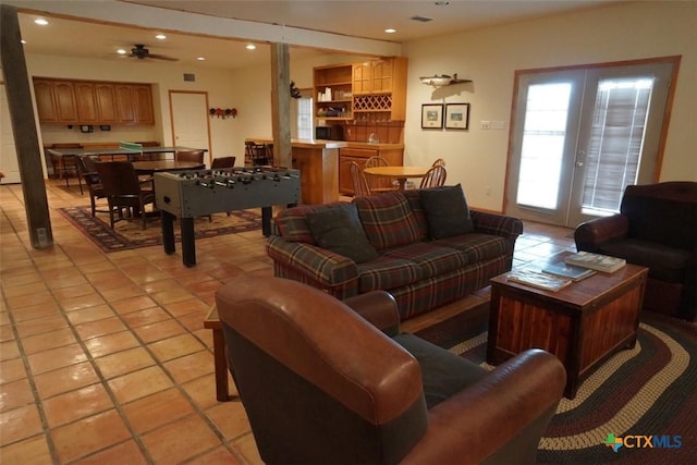 living room with french doors, ceiling fan, and light tile patterned floors