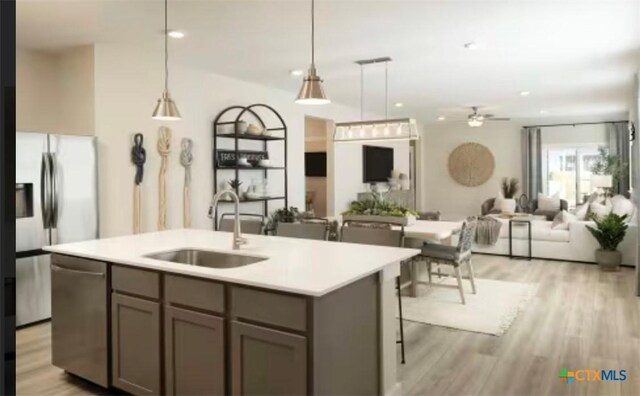 544 Bauer Loop, Liberty Hill, TX 78642 - kitchen with appliances with stainless steel finishes, open floor plan, a ceiling fan, light wood finished floors, and light countertops