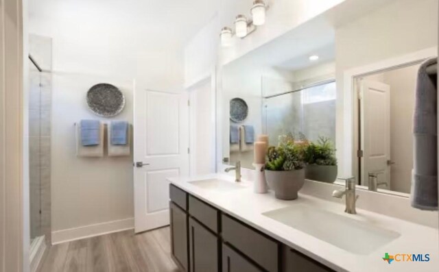 544 Bauer Loop, Liberty Hill, TX 78642 - bathroom featuring double vanity, an enclosed shower, and wood finished floors