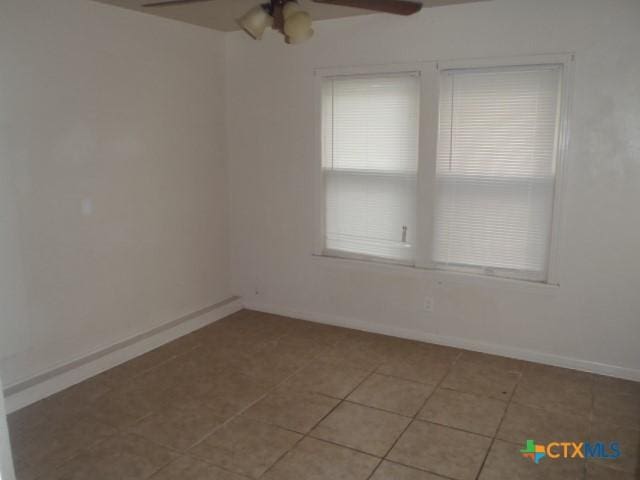 unfurnished room featuring light tile patterned floors, ceiling fan, and baseboards