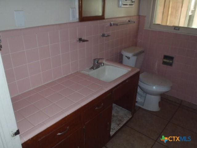 335 Hot Wells Blvd, San Antonio, TX 78223 - bathroom featuring tile patterned flooring, tile walls, vanity, and wainscoting