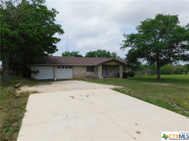 ranch-style house with a garage and a front lawn