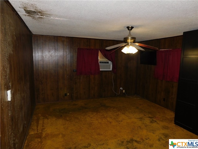 carpeted spare room with a wall mounted AC, wooden walls, a textured ceiling, and ceiling fan