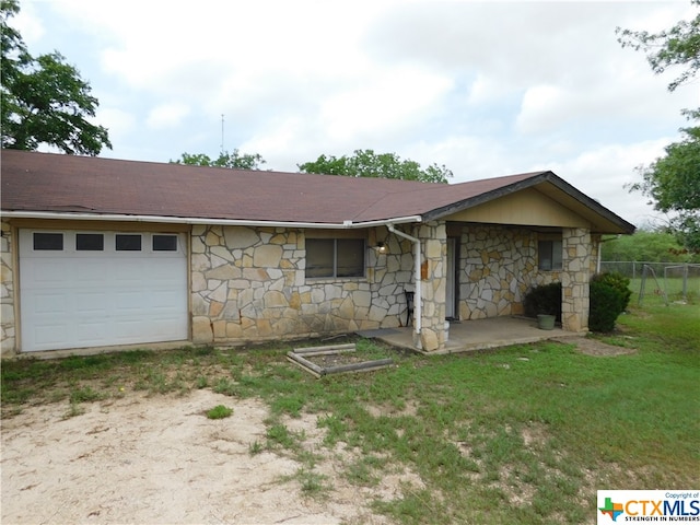 ranch-style home with a garage and a front yard