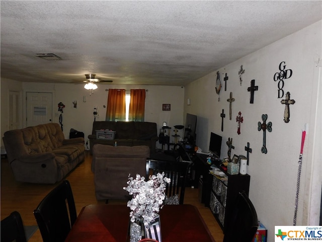 dining area with a textured ceiling, hardwood / wood-style flooring, and ceiling fan