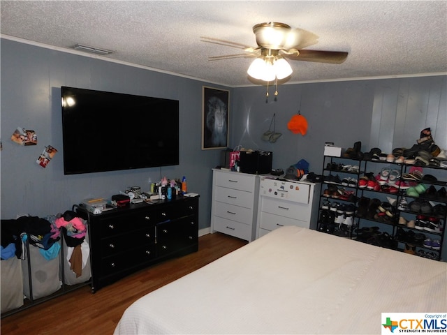 bedroom with dark hardwood / wood-style flooring, ornamental molding, a textured ceiling, and ceiling fan