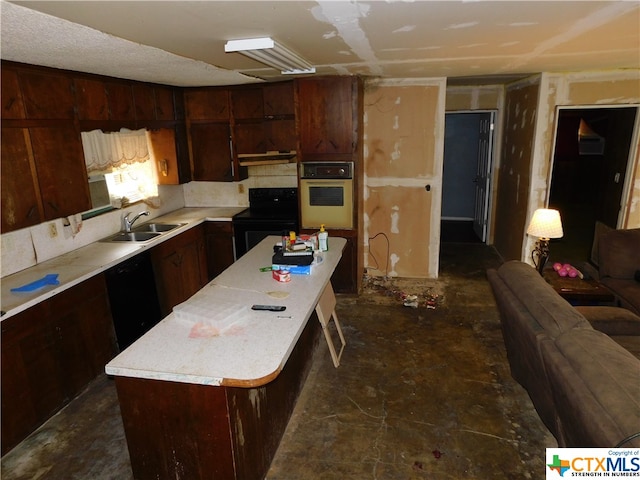 kitchen featuring a center island, dark brown cabinetry, black appliances, sink, and a breakfast bar