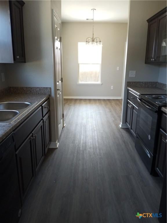 2703 Cardinal St, Victoria, TX 77901 - kitchen with black appliances, dark wood-style flooring, dark countertops, and a chandelier