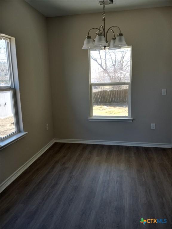 2703 Cardinal St, Victoria, TX 77901 - unfurnished dining area featuring a chandelier, dark wood finished floors, and plenty of natural light