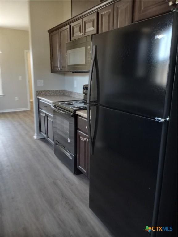 2703 Cardinal St, Victoria, TX 77901 - kitchen featuring black appliances, light wood-style floors, and light countertops