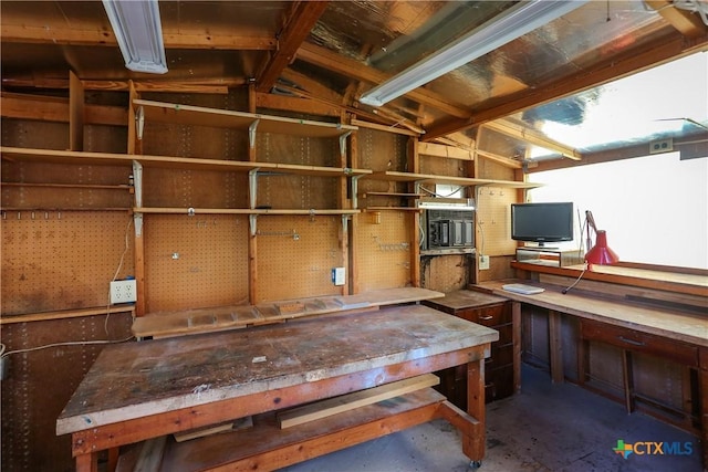 misc room with a workshop area and concrete flooring