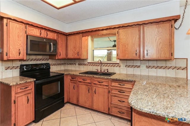 kitchen with stainless steel microwave, black range with electric stovetop, a sink, tasteful backsplash, and brown cabinets