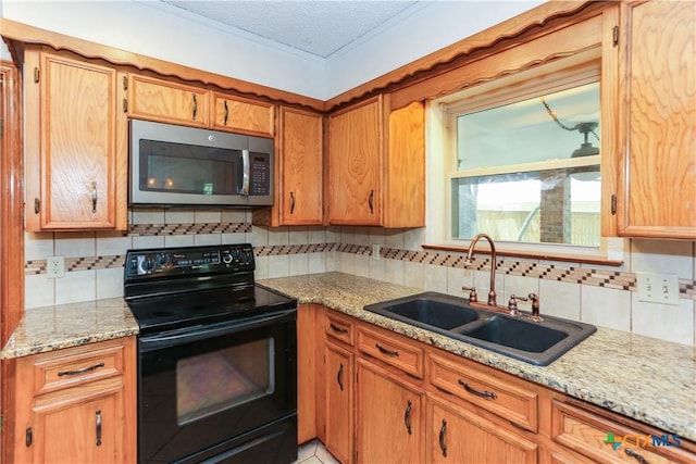 kitchen with stainless steel microwave, black electric range, a sink, decorative backsplash, and a textured ceiling