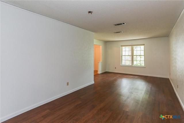 empty room featuring dark wood finished floors, baseboards, fire sprinkler in ceiling, and a textured ceiling